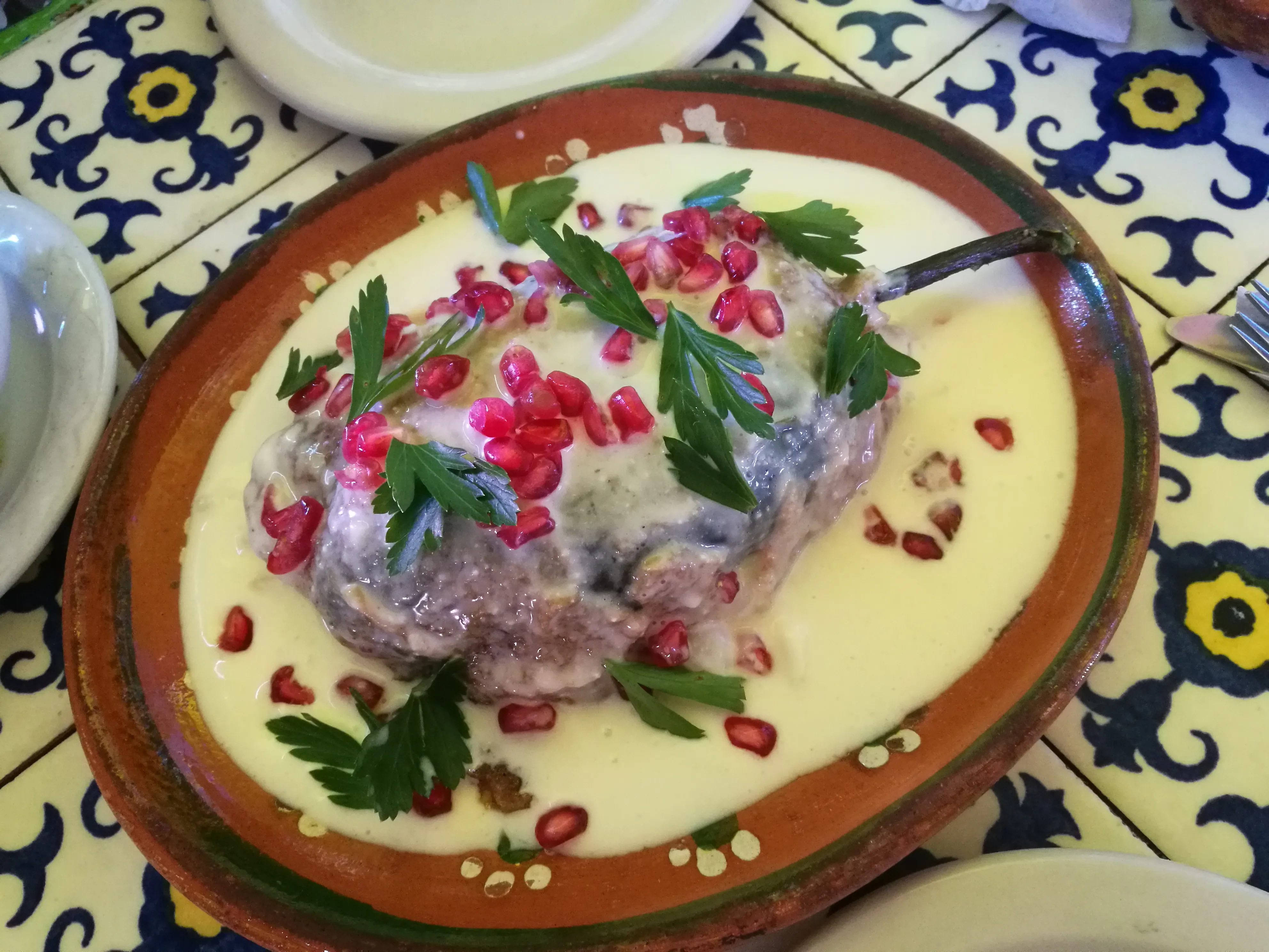 Chile en Nogada are stuffed poblano peppers in walnut sauce. The dish represents the colors of the Mexican flag and is traditionally eaten around independence day.